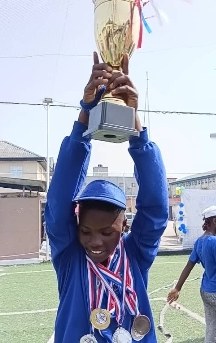 Student lifting the Inter-House Sports trophy